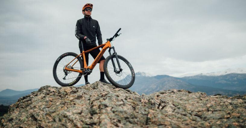 Ein Radfahrer steht mit seinem Mountainbike auf einem Felsen