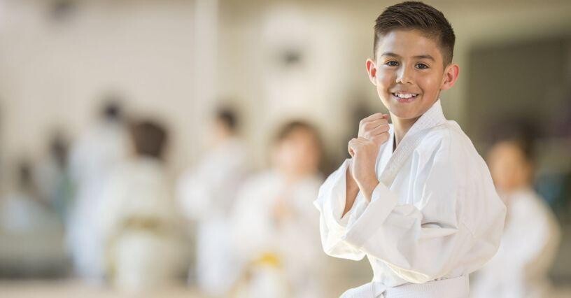 Ein Kind trägt einen Karateanzug im Dojo
