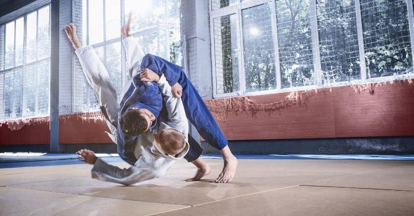 Zwei Judoka führen einen Wurf auf der Matte aus